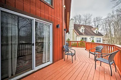 a deck with two chairs and a sliding glass door at Golf, Ski and Fish Cabin with Deck in Tobyhanna! in Tobyhanna