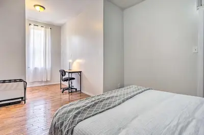 a bedroom with a bed and a table with a chair at Updated Bayonne Townhome about 11 Mi to NYC! in Bayonne