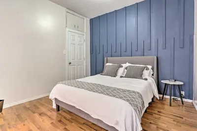 a bedroom with a bed and a blue wall at Updated Bayonne Townhome about 11 Mi to NYC! in Bayonne
