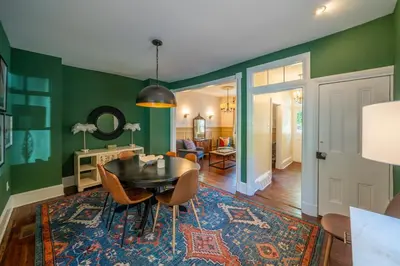 a dining room with green walls and a table and chairs at The Walton House - historic 3bd 2 5ba with parking in Kennett Square