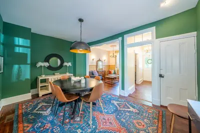 a dining room with green walls and a table and chairs at The Walton House - historic 3bd 2 5ba with parking in Kennett Square