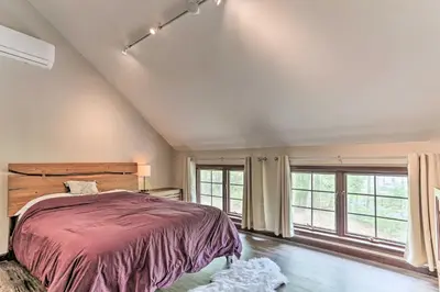a bedroom with a large bed and large windows at Updated Stroudsburg Home with Spacious Deck! in Stroudsburg