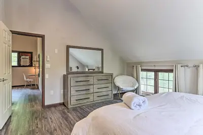 a bedroom with a bed and a dresser with a mirror at Updated Stroudsburg Home with Spacious Deck! in Stroudsburg