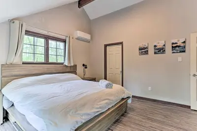 a bedroom with a large bed and a window at Updated Stroudsburg Home with Spacious Deck! in Stroudsburg