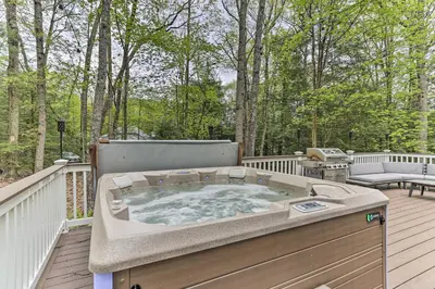 a jacuzzi tub on a deck with trees at Updated Stroudsburg Home with Spacious Deck! in Stroudsburg
