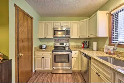a kitchen with white cabinets and stainless steel appliances at Ian's Camelback House in Tannersville