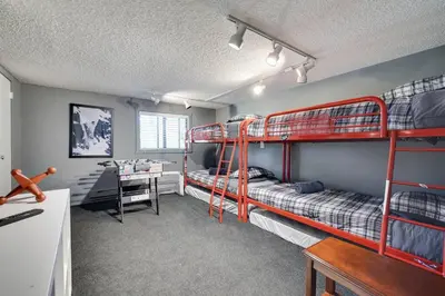 a room with two bunk beds and a desk at Garrett's Camelback House in Tannersville