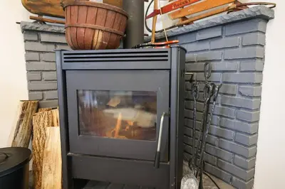 a television sitting next to a brick fireplace at Garrett's Camelback House in Tannersville
