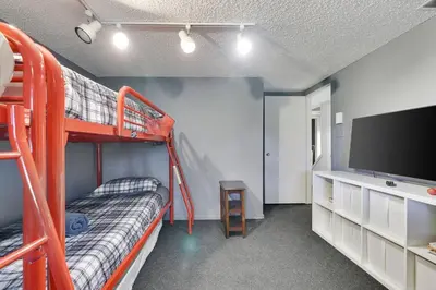 a room with two bunk beds and a flat screen tv at Garrett's Camelback House in Tannersville