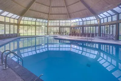 a large swimming pool in a building with a roof at Garrett's Camelback House in Tannersville