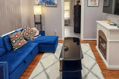 a blue couch in a living room with a fireplace at 11 Mi to Manhattan Pet-Friendly Duplex with Yard! in Teaneck