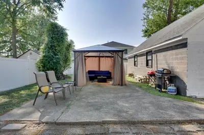 a patio with two chairs and a blue umbrella at 11 Mi to Manhattan Pet-Friendly Duplex with Yard! in Teaneck