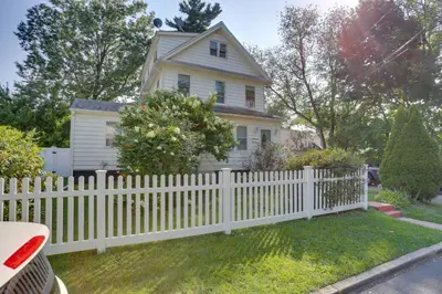 a white picket fence in front of a house at 11 Mi to Manhattan Pet-Friendly Duplex with Yard! in Teaneck