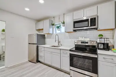 a kitchen with white cabinets and stainless steel appliances at Luxurious 2BD family friendly, central in Philadelphia