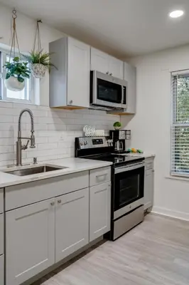 a white kitchen with a sink and a microwave at Luxurious 2BD family friendly, central in Philadelphia