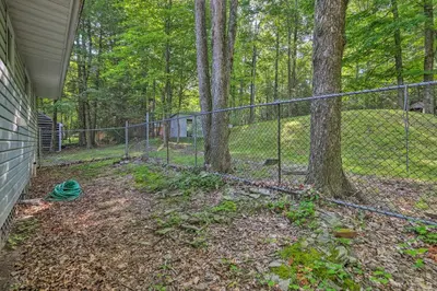 a chain link fence next to a yard with trees at 22 Mi to Ski Big Bear! Lake Wallenpaupack Getaway in Greentown