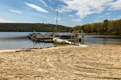 a group of boats docked at a dock on a lake at Big Boulder Bliss in Lake Harmony
