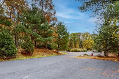 an empty road in the middle of a forest at Big Boulder Bliss in Lake Harmony
