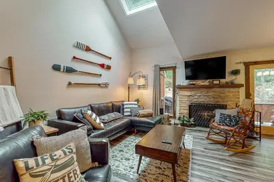 a living room with a leather couch and a fireplace at Big Boulder Bliss in Lake Harmony