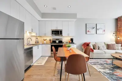 a kitchen and living room with a table and a couch at Elegant Main Street Living* Near NYC in Hackensack