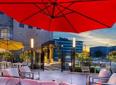 a patio with red umbrellas and tables and chairs at Elegant Main Street Living* Near NYC in Hackensack