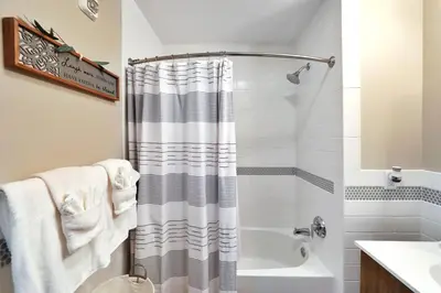 a bathroom with a shower curtain and a tub at Elegant Main Street Living* Near NYC in Hackensack