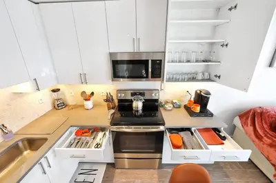 a kitchen with white cabinets and a stove top oven at Elegant Main Street Living* Near NYC in Hackensack
