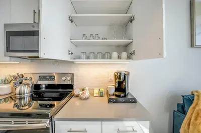 a kitchen with white cabinets and a stove at Stylish 1br Unit. Parking. Easy Ride to NYC in Hackensack