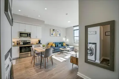 a kitchen and living room with a table and chairs at Stylish 1br Unit. Parking. Easy Ride to NYC in Hackensack