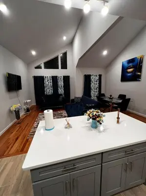 a kitchen with a counter top and a living room at SPRINGVIEW HOMES 12MINS FROM EWR & 3 MINS FROM UNIVERSITY HOSPITAL in Newark