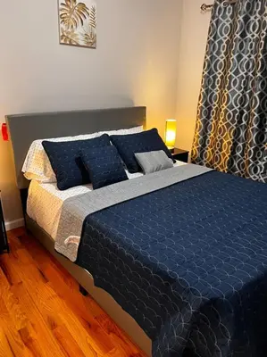 a blue bed with blue pillows in a bedroom at SPRINGVIEW HOMES 12MINS FROM EWR & 3 MINS FROM UNIVERSITY HOSPITAL in Newark