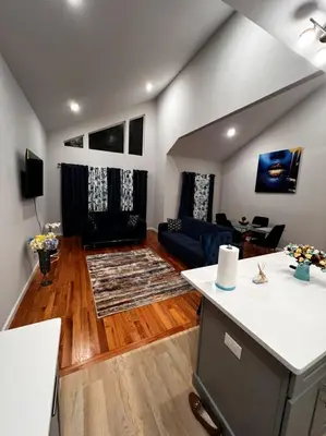 a living room with a couch and a table at SPRINGVIEW HOMES 12MINS FROM EWR & 3 MINS FROM UNIVERSITY HOSPITAL in Newark