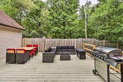 a patio with a grill and a table and chairs at Chic Long Pond Family Home with Fire Pits and Deck! in Long Pond
