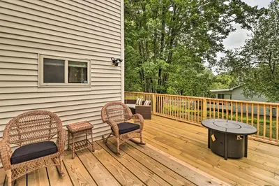 a wooden deck with two chairs and a table at Chic Long Pond Family Home with Fire Pits and Deck! in Long Pond