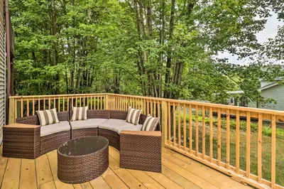 a porch with a couch on a wooden deck at Chic Long Pond Family Home with Fire Pits and Deck! in Long Pond