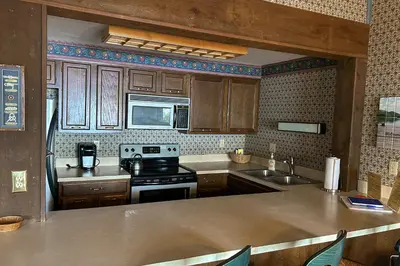a kitchen with wooden cabinets and a stove top oven at Big Boulder Lake Townhome in Lake Harmony