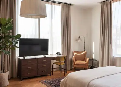 a hotel room with a television and a desk with a chair at The Quoin Hotel in Wilmington