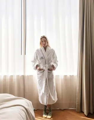 a woman dressed in white standing in front of a window at The Quoin Hotel in Wilmington