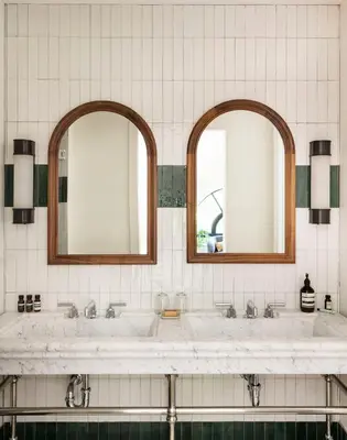 a bathroom with two sinks and two mirrors at The Quoin Hotel in Wilmington