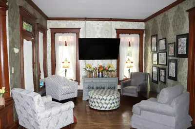a living room with two chairs and a flat screen tv at VAAST Bed & Breakfast in Adamstown
