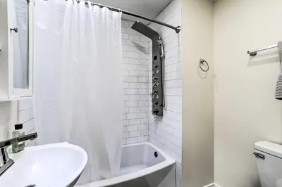 a white bathroom with a shower and a sink at Philadelphia Townhome Less Than 8 Mi to Center City! in Philadelphia