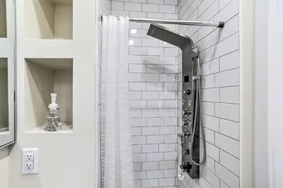 a bathroom with a shower with white tiles at Philadelphia Townhome Less Than 8 Mi to Center City! in Philadelphia