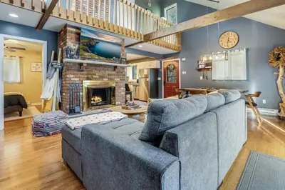 a living room with a blue couch and a fireplace at Hot Tub, Fire Pit and Barrel Sauna Poconos Abode in Long Pond