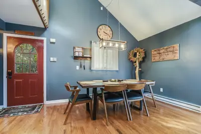 a dining room with a table and chairs and a red door at Hot Tub, Fire Pit and Barrel Sauna Poconos Abode in Long Pond
