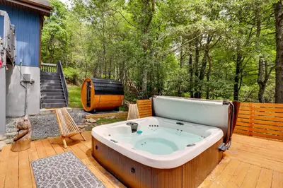 a jacuzzi tub sitting on a wooden deck at Hot Tub, Fire Pit and Barrel Sauna Poconos Abode in Long Pond