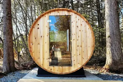 a wooden circle with a glass door in the woods at Lake Access! Catskill Cozy Home- Hot-Tub, Sauna in Loch Sheldrake