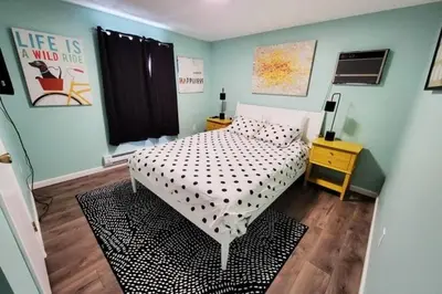 a bedroom with a bed with a black and white comforter at Lake Access! Catskill Cozy Home- Hot-Tub, Sauna in Loch Sheldrake