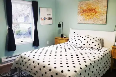a bedroom with a bed with a black and white comforter at Lake Access! Catskill Cozy Home- Hot-Tub, Sauna in Loch Sheldrake