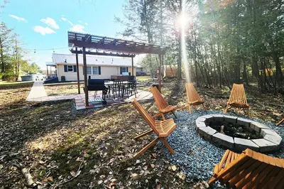 a group of chairs and a fire pit in a yard at Lake Access! Catskill Cozy Home- Hot-Tub, Sauna in Loch Sheldrake