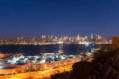 a view of a city at night with a harbor at Warm 3 BR for U Near Manhattan View, 15 Min to NYC in West New York